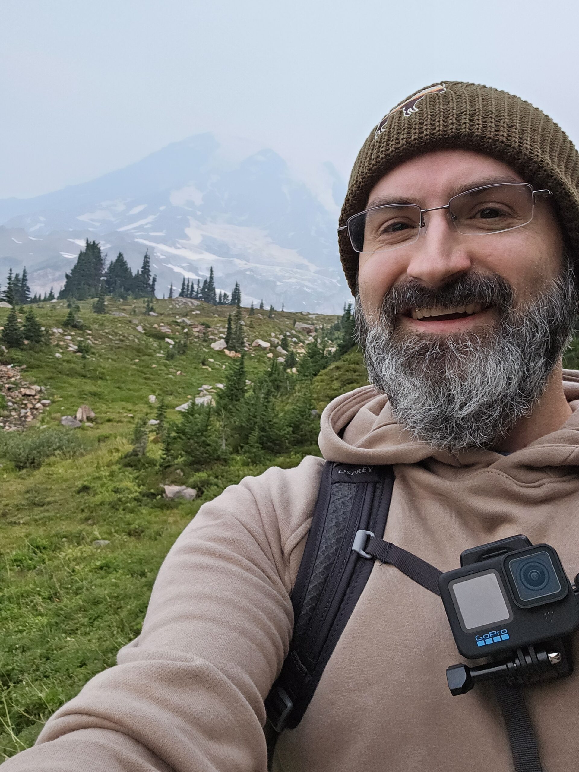 Selfie posing with Mount Ranier in the background. GoPro Camera attached to chest.